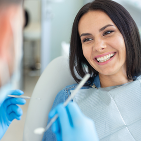 Compton Family Dental doctor explaining a procedure to an elderly man in a dental chair